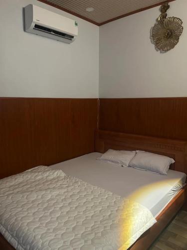 a white bed in a room with a fan at Hoàng Yến Hotel Thanh Hoà in Cai Lậy