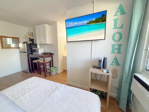 a small room with a bed and a kitchen at Mellow Kuhio Village Studio condo in Honolulu