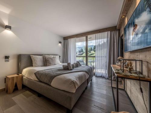 a bedroom with a large bed and a large window at Appartement moderne Courchevel 1550, 4 personnes, parking, wifi - FR-1-631-234 in Courchevel