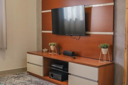a flat screen tv hanging on a wall at Loft Encantador com Ar Cond prox Centro in Itatiba
