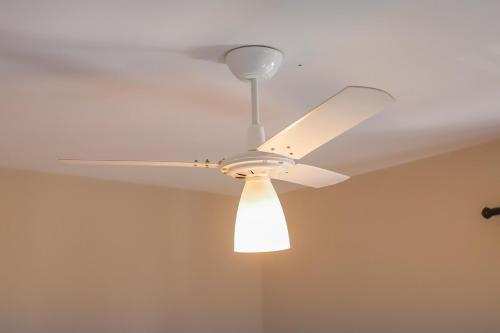 a white ceiling fan with a light on it at Loft Encantador com Ar Cond prox Centro in Itatiba