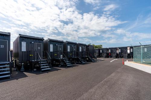 a row of black containers parked in a parking lot at HOTEL R9 The Yard Acrossplazakanuma in Kanuma