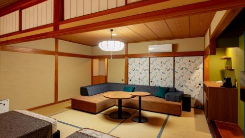 a living room with a couch and a table at Kinosaki Onsen Kawaguchiya Honkan in Toyooka