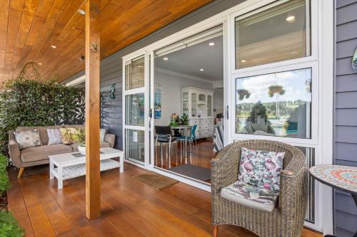 a screened in porch with chairs and a table at The Weiti Waterfront in Whangaparaoa