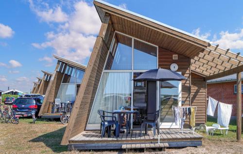 a small house with a table and an umbrella at Holiday Home Hvide Sande 9 in Hvide Sande