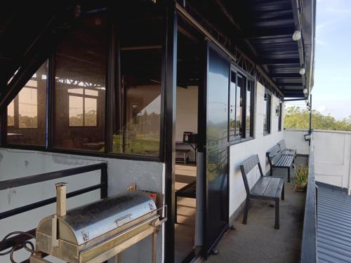 a building with a porch with two benches and windows at Kua's Pad Tagaytay in Tagaytay