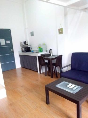 a living room with a table and a blue couch at Kua's Pad Tagaytay in Tagaytay