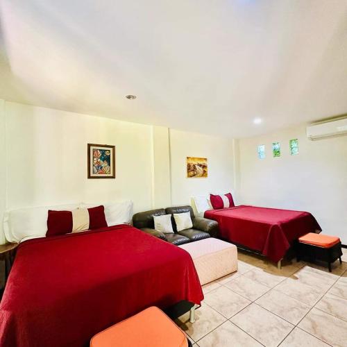 a living room with two beds and a couch at Guazapa Cafe hotel petit in Suchitoto