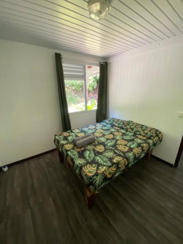 a bedroom with a bed in a room with a window at TIKI LODGE Hiva oa in Atuona