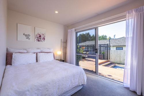 een slaapkamer met een bed en een groot raam bij Modern on Miro in Ohakune