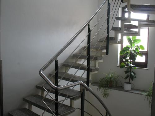 a staircase with a metal railing and plants at Pension Hinz & Kunz in Weimar