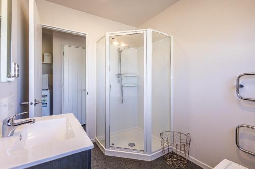 een badkamer met een douche en een wastafel bij Modern on Miro in Ohakune