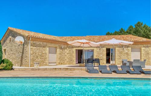 a stone house with a swimming pool and chairs and umbrellas at Charmante Maison Avec Piscine in La Douze