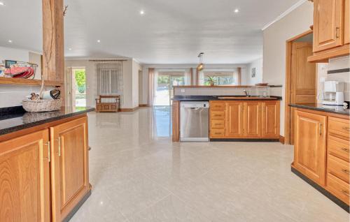 a large kitchen with wooden cabinets and appliances at Charmante Maison Avec Piscine in La Douze