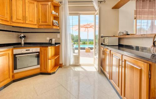 a kitchen with wooden cabinets and black counter tops at Charmante Maison Avec Piscine in La Douze