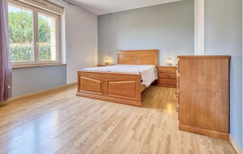 a bedroom with a bed and a dresser and a window at Charmante Maison Avec Piscine in La Douze