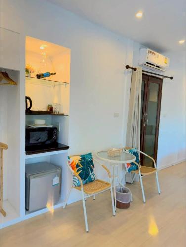 a dining room with a table and two chairs at The bora bora - Bed and Dream เดอะ โบรา โบร่า - เบด แอนด์ ดรีม in Ban Chek