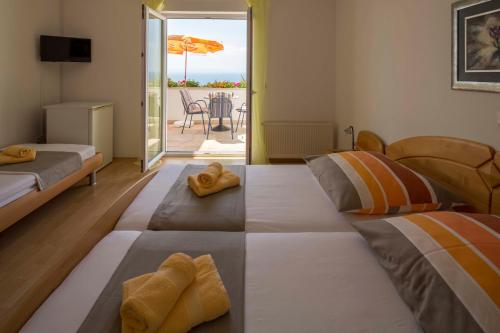 a room with two beds and a balcony with an umbrella at Villa Ruza in Makarska