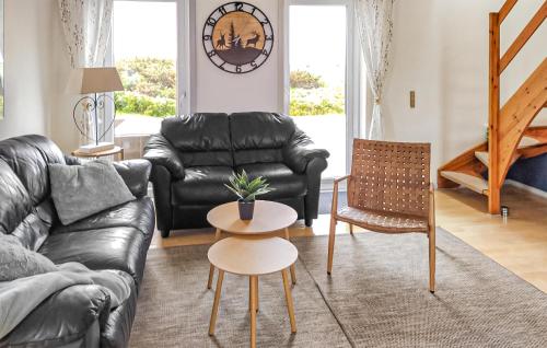 a living room with a black leather couch and a table at Lejlighed 190 in Rømø