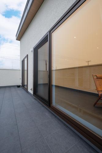 a balcony with large sliding glass doors on a house at Villa Cangrejo in Shiraoi