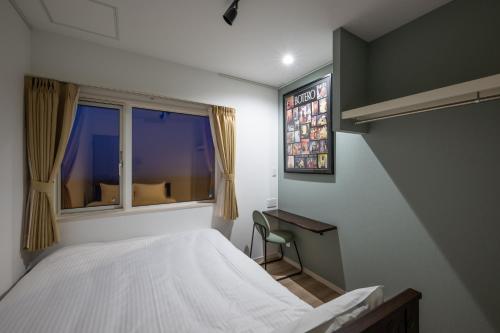 a bedroom with a bed and a window at Villa Cangrejo in Shiraoi
