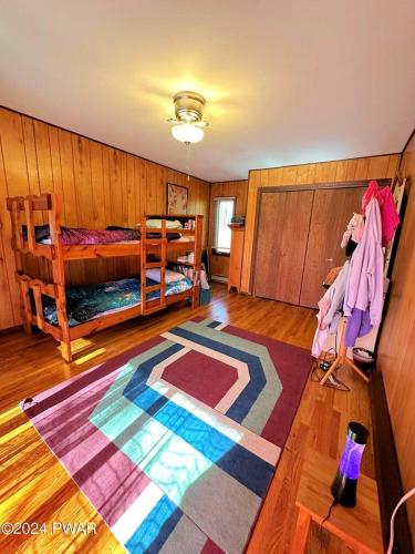 a room with two bunk beds and a rug at Paradise Uncovered Chalet Near Lake in Hawley