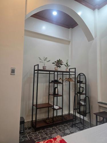 a room with two shelves with plants on a wall at Homestay Mai Ngọc Tây Ninh in Tây Ninh