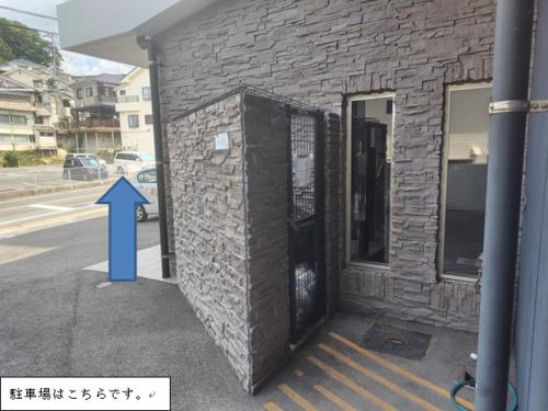 a brick building with a blue arrow next to it at ステイインアット今福 in Sasebo