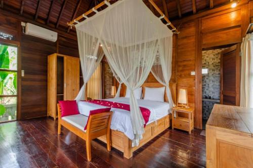 a bedroom with a bed with a canopy at Precious Journey Retreat in Ubud