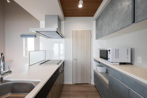 a kitchen with a sink and a microwave at Villa Cangrejo in Shiraoi