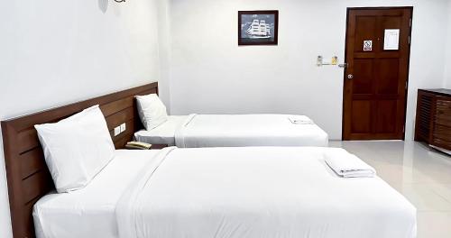 a hotel room with two beds and a door at Perfect Place Hotel in Surat Thani