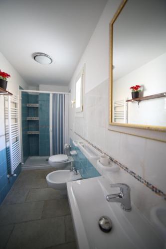 a bathroom with two sinks and two toilets and a mirror at La Corte Delle Sterne in Morciano di Leuca