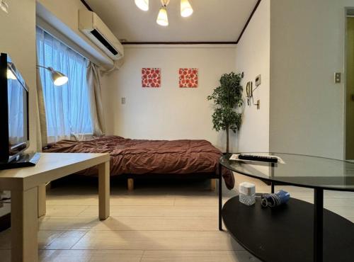 a small room with a bed and a table at 京橋プルトンビル in Osaka