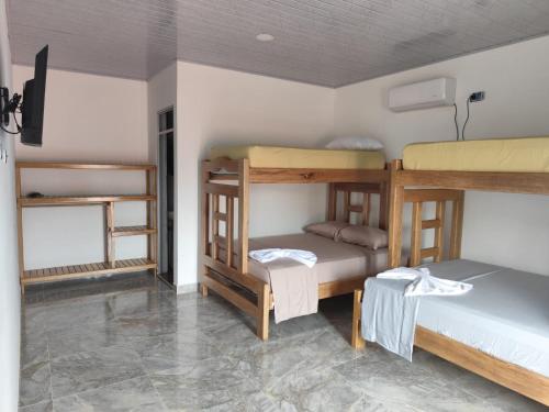 a room with three bunk beds in a room at Habitaciones con wifi a 5 minutos de la playa in Capurganá