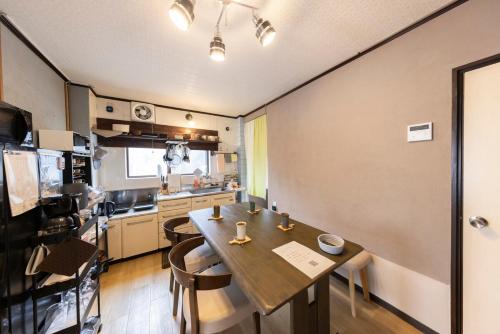 a kitchen with a wooden table in a room at 貸切宿 ひととき -Hitotoki- 眺めの良いテラスでBBQが楽しめる 徒歩で海と温泉へ 温泉券プレゼント 最大12名 in Numazu