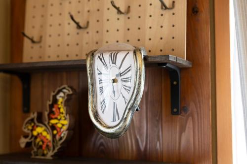 a clock is hanging on a wooden wall at 貸切宿 ひととき -Hitotoki- 眺めの良いテラスでBBQが楽しめる 徒歩で海と温泉へ 温泉券プレゼント 最大12名 in Numazu