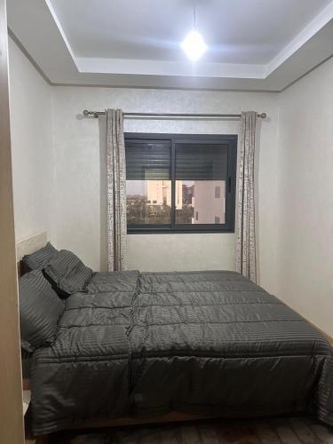 a bed in a bedroom with a window at Ocean Park Apartment for rent in Casablanca