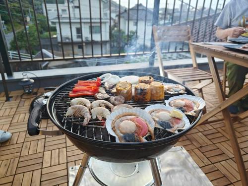 a grill with different types of food on it at 貸切宿 ひととき -Hitotoki- 眺めの良いテラスでBBQが楽しめる 徒歩で海と温泉へ 温泉券プレゼント 最大12名 in Numazu