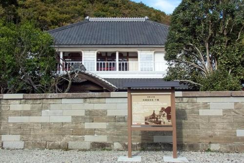 a sign in front of a building with a house at 貸切宿 ひととき -Hitotoki- 眺めの良いテラスでBBQが楽しめる 徒歩で海と温泉へ 温泉券プレゼント 最大12名 in Numazu