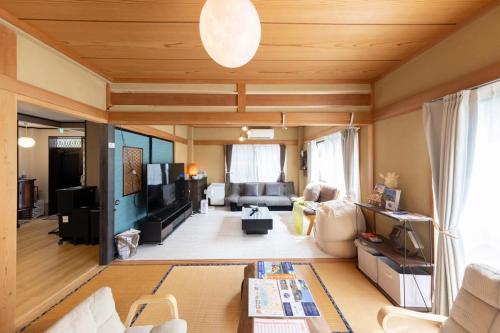 a living room with a couch and a table at 貸切宿 ひととき -Hitotoki- 眺めの良いテラスでBBQが楽しめる 徒歩で海と温泉へ 温泉券プレゼント 最大12名 in Numazu