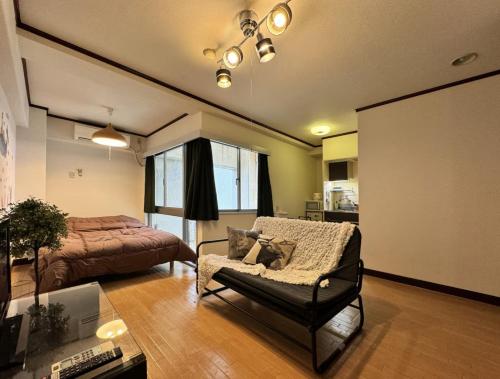 a living room with a couch and a bed at 京橋プルトンビル in Osaka