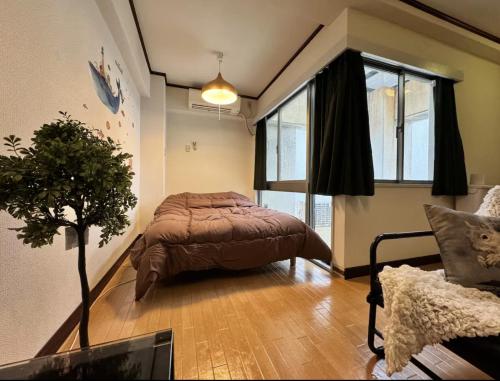 a bedroom with a bed and a tree in it at 京橋プルトンビル in Osaka