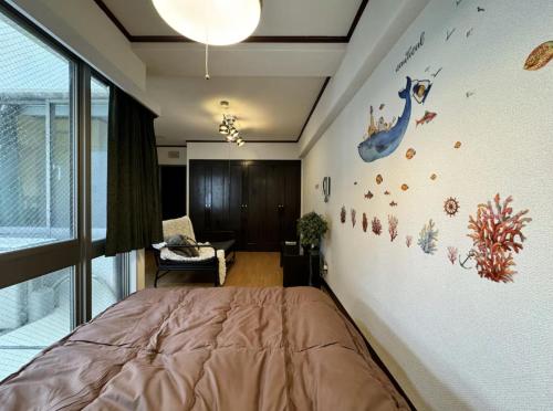 a bedroom with a bed and a wall with a dinosaur sticker at 京橋プルトンビル in Osaka