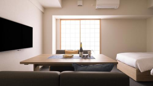 a room with a couch and a table and a bed at MIMARU Osaka Shinsaibashi East in Osaka