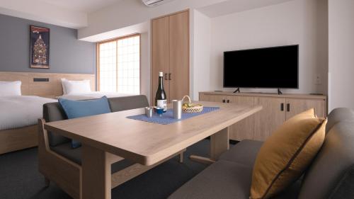 a living room with a table and a television at MIMARU Osaka Shinsaibashi East in Osaka