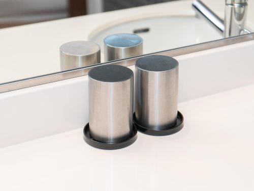 a bathroom counter with a mirror and a sink at Sutton Hotel Hakata City in Fukuoka