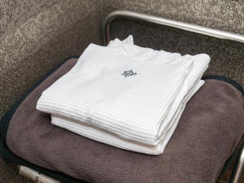 a pile of white towels sitting on a suitcase at Sutton Hotel Hakata City in Fukuoka