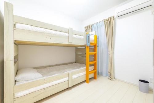 a bedroom with two bunk beds with a ladder at Near Shinjuku 3 stops in Tokyo