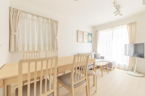 a dining room with a table and chairs and a television at Near Shinjuku 3 stops in Tokyo