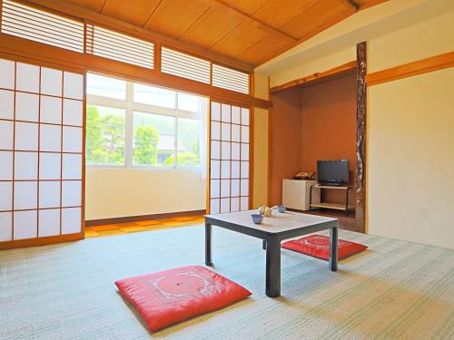 a room with a table and a red rug at Minshuku Miyama in Yamanouchi